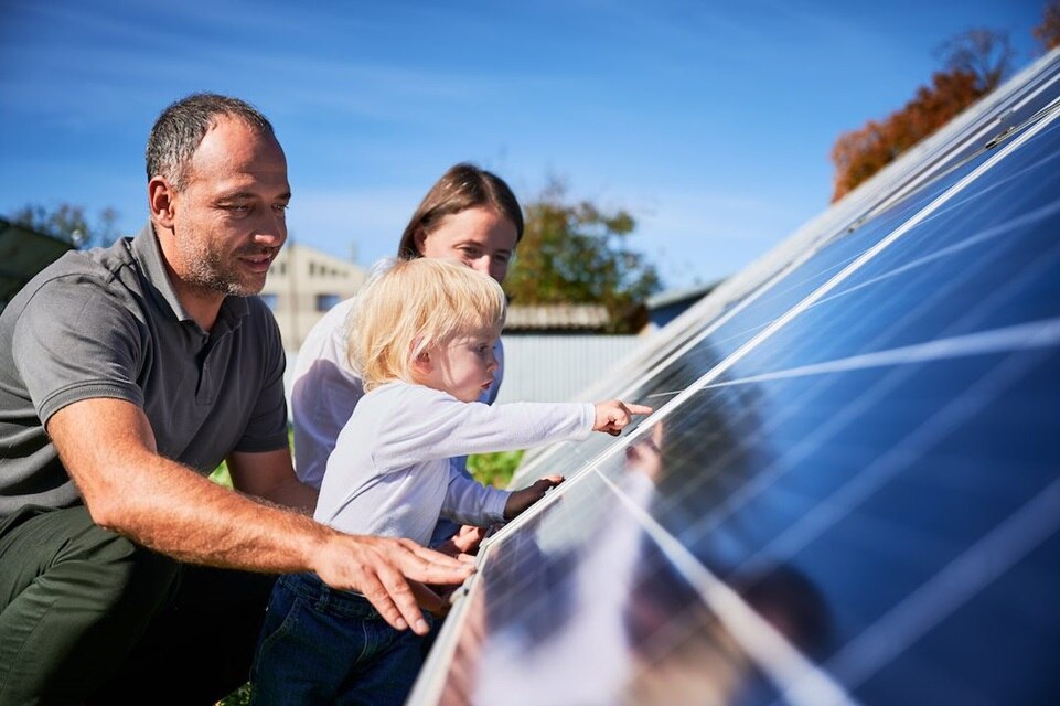 Young Family looking at solar panel