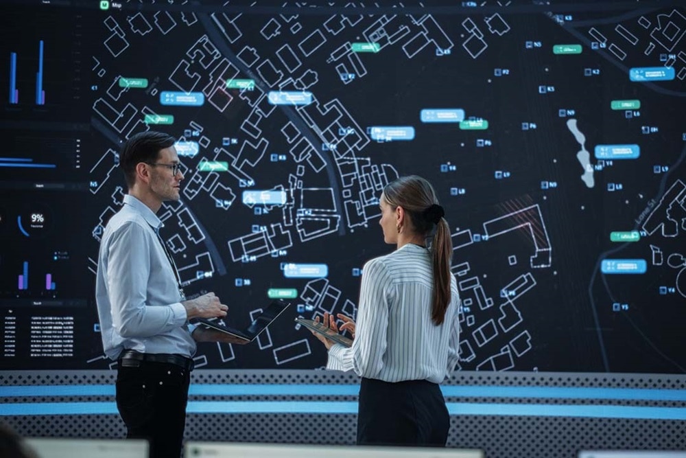 Data analysts discussing in front of digital city map