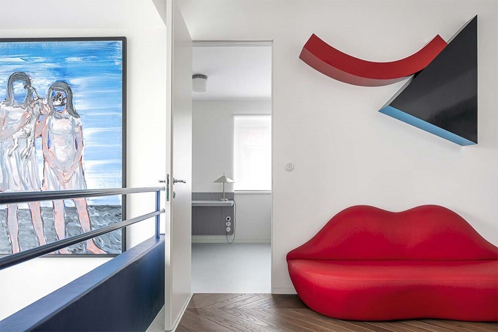 hager group room with red design coach and design objects hanging on the wall