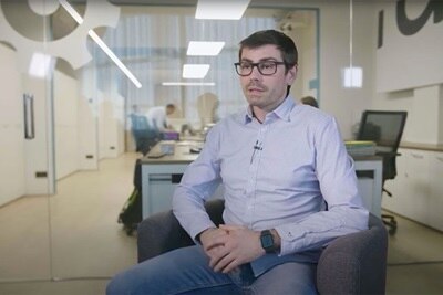 Persona sentada en un entorno de oficina con lámparas modernas de iluminación en el fondo