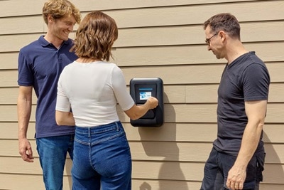 femme met carte devant borne de recharge, 2 hommes regardent