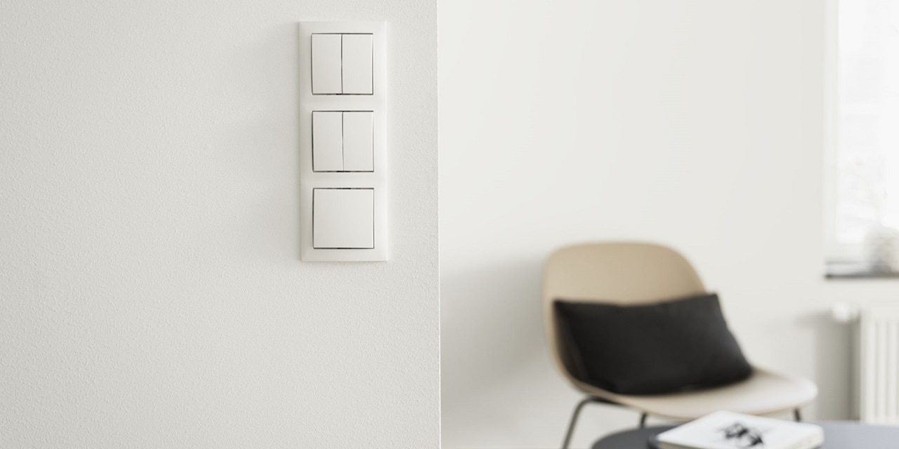 Intérieur minimaliste avec des interrupteurs blancs, une chaise avec un coussin et une table près d'une fenêtre avec un radiateur.