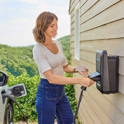 femme qui charge sa voiture avec une borne de recharge