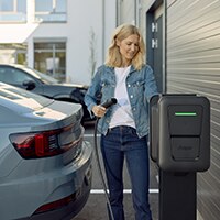 Femme qui recharge sa voiture sur un parking privé avec une borne witty pro de Hager