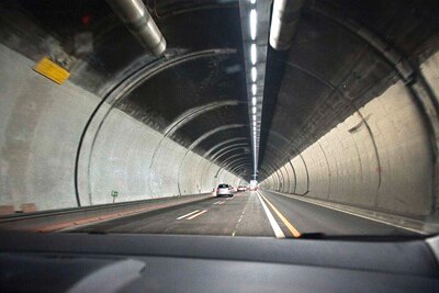 Vue depuis une voiture circulant dans un tunnel bien éclairé avec des luminaires électriques au plafond