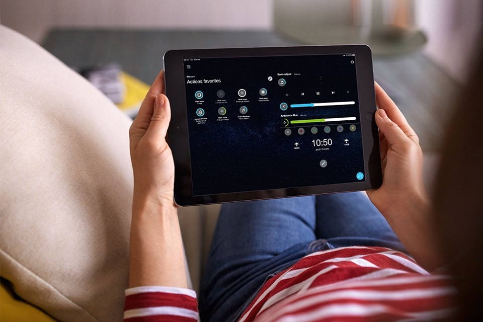 Personne utilisant une tablette avec une interface de domotique pour le contrôle du système d'automatisation domestique