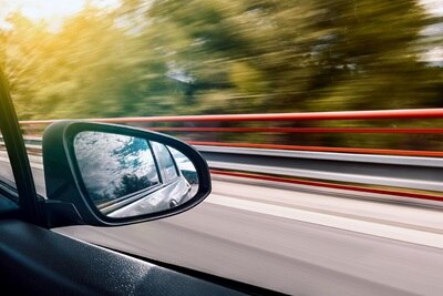 Vue de la fenêtre d'un véhicule électrique, coté passager, rétroviseur et impression de vitesse 