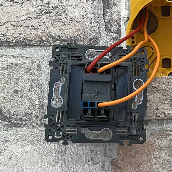Raccordez le fil de phase (rouge ou marron) sur la borne L du premier interrupteur va-et-vient et les fils navette (orange) sur les bornes 1 et N2.