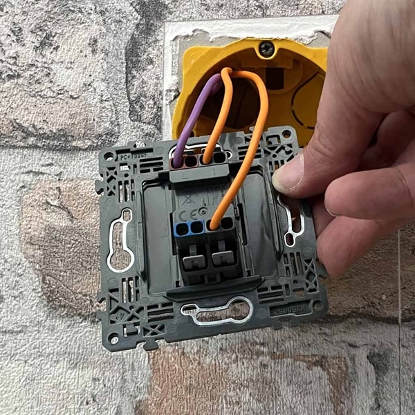 Raccordez le fil de retour lampe (violet) sur la borne L du second interrupteur va-et-vient et les fils navette (orange) sur les bornes 1 et N2.