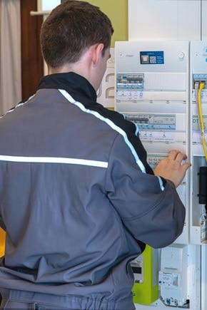 Apprenti devant un tableau électrique Hager