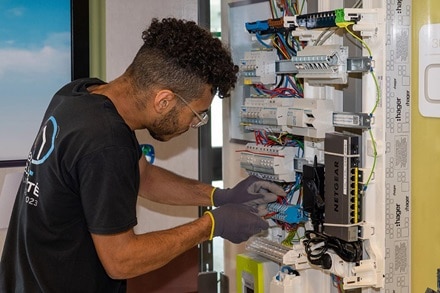 Elève en train de câbler dans un tableau électrique lors du Concours Général des Lycées et des Métiers 2023