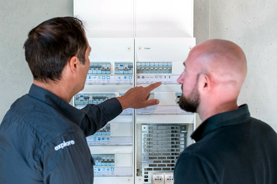 Deux professionnels examinent l’organisation d’un tableau électrique