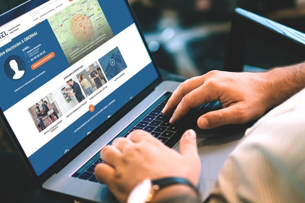 Homme qui cherche un électricien elexium Hager sur son PC portable 