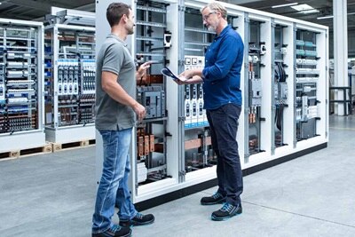 2 hommes devant des armoires de distribution d’énergie Hager