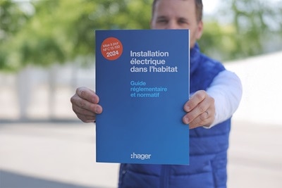 Homme qui tend le guide NF C 15-100 édition 2024