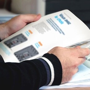 personne qui consulte une brochure Hager