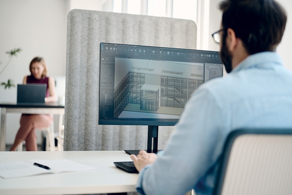 homme au bureau devant PC utilisant hagercad.T, logiciel qui exporte la modelisation des donnees du batiment (BIM)