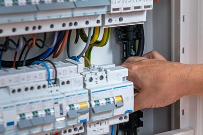 homme qui installe facilement les appareillages modulaires dans le coffret vegaD de Hager