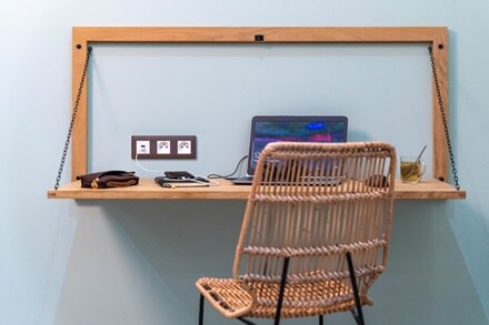 appareillage mural essensya de Hager, plaque 3 postes, finition terra, fonctions prises 2P+1T et USB A+C alimentant un smartphone sur un poste de téléravail avec ordinateur portable. 