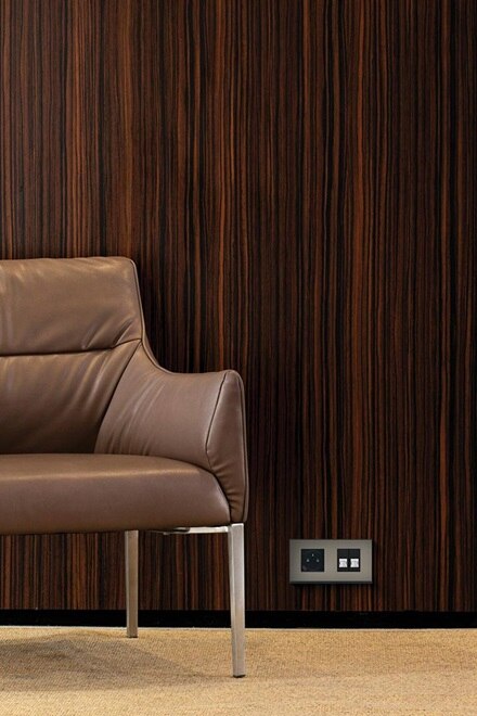 Double prise affleurante avec USB-C  et double prise RJ45 plaque placage acier gallery de Hager dans une chambre d'hôtel sur un mur bois foncé