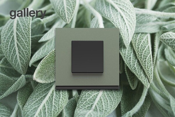 Interrupteur gallery personnalisé par Manufaktur by Hager Exclusive, plaque en matière veloutée vert sauge sur fond de feuilles de sauge verte