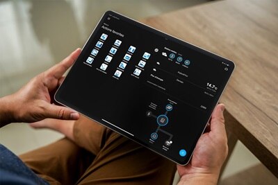 Homme tenant un iPad qui consulte domovea de Hager pour piloter les automatismes de sa maison