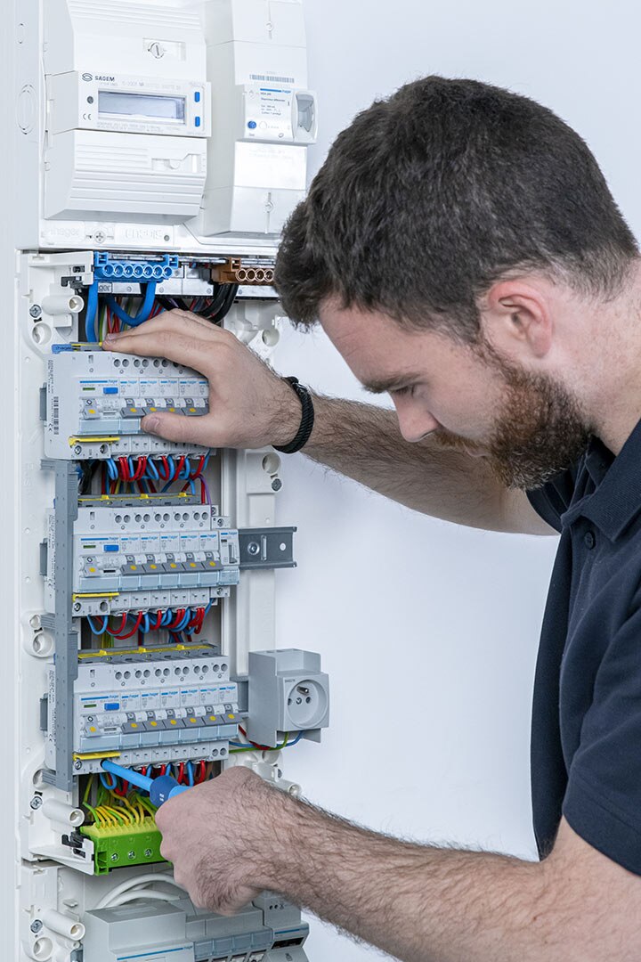 Électricien intervenant sur le tableau d’une habitation