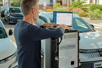 Installateur électricien qui programme une borne de recharge tertiaire witty park 2