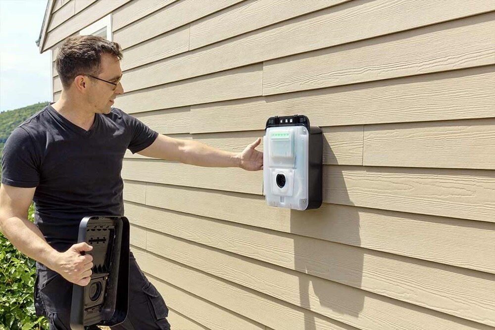 Installateur IRVE occuper à installer une borne de recharge witty one de Hager posée sur le mur d'une hanitation