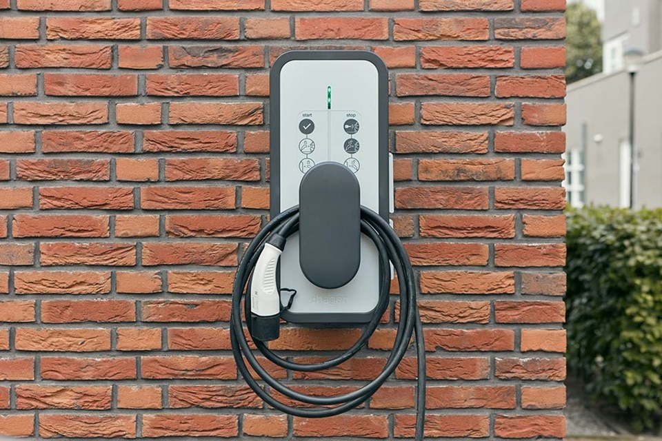 Borne de recharge witty start de Hager fixée sur un mur en brique