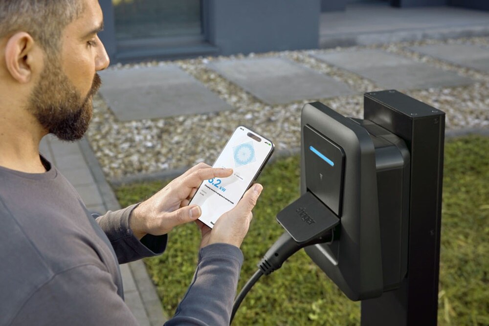 Homme qui utilise l'application Hager Charge pour piloter sa borne de recharge witty plus de Hager