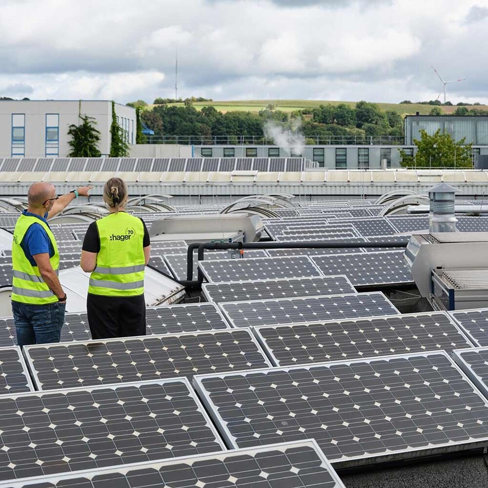 Couple de professionnels sur toiture de magasin avec panneaux solaires photovoltaïques
