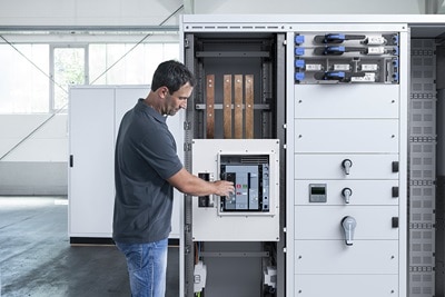 Homme qui actionne un disjoncteur dans un tableau électrique