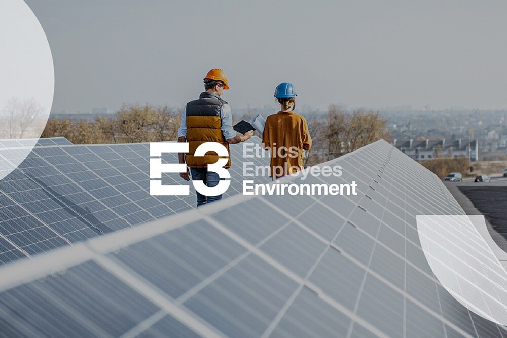 Illustration de l'approche 3E (Employés, Ethique, Environnement) sur le développement durable par Hager Group, un homme et une femme , en tenue de chantier, sur des toits de panneaux photovoltaïques