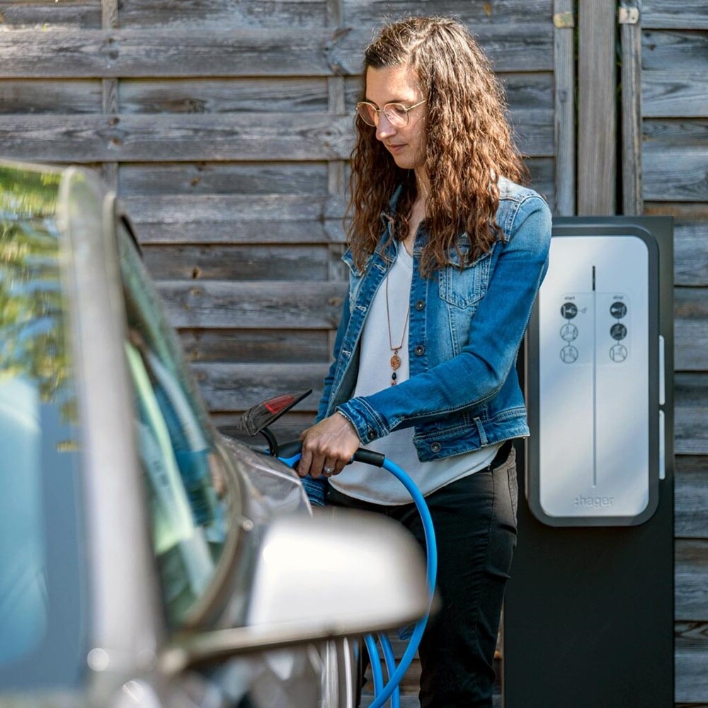 Borne de recharge witty de Hager, utilisatrice chargeant son véhicule électrique