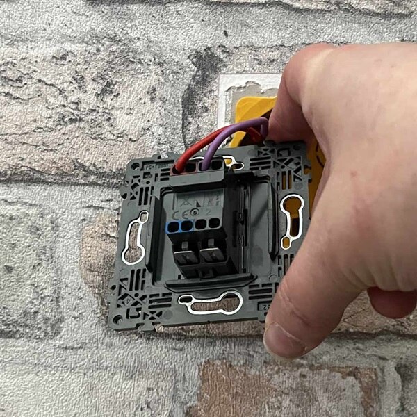 Raccordez le fil de phase (rouge ou marron) sur la borne L de l'interrupteur et le fil de retour (violet) sur la borne 1.