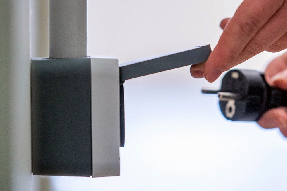 Main branche une prise de courant dans une prise cubyko étanche montée en saillie