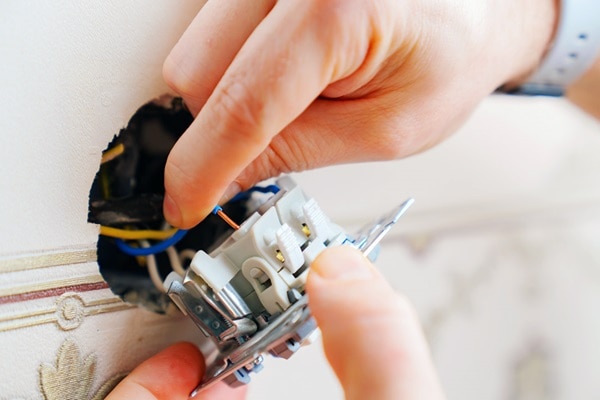 Homme qui raccorde un interrupteur