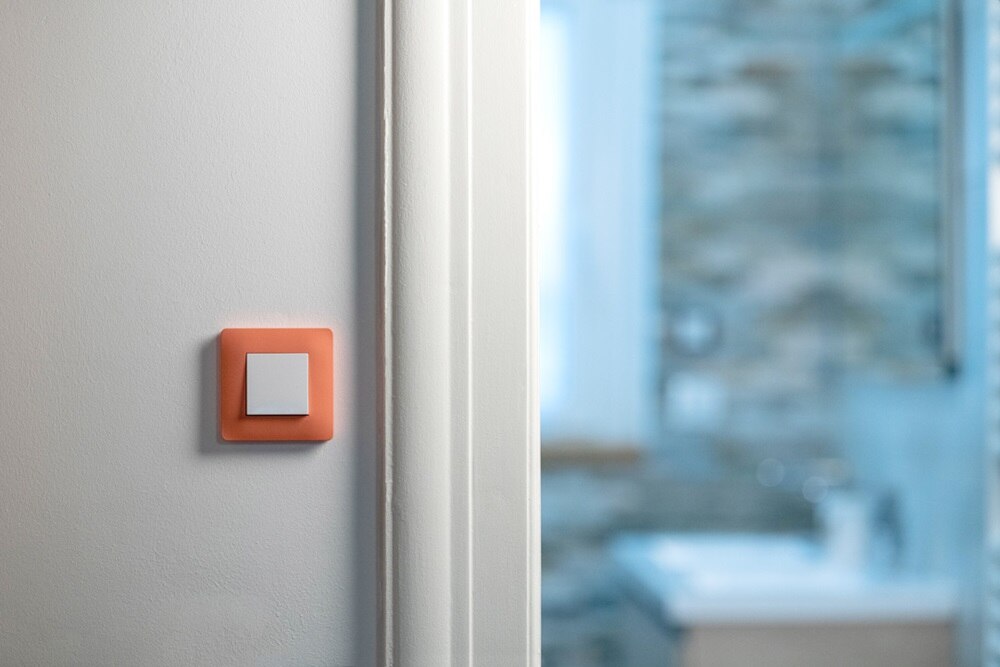 appareillage mural essensya coral de Hager, interrupteur va-et-vient bouton-poussoir dans un couloir