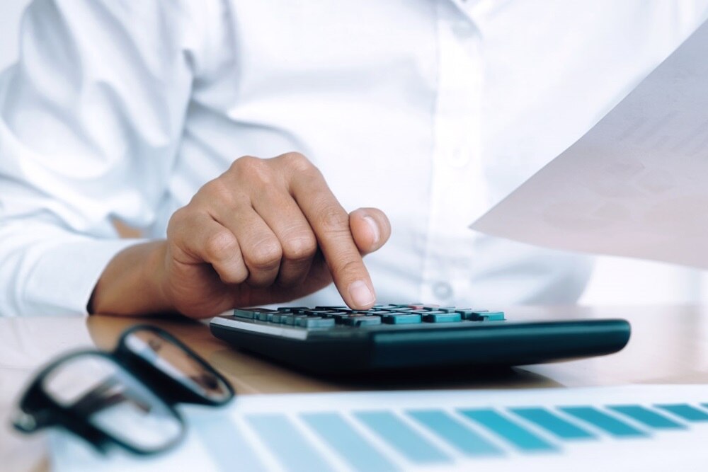 main de femme qui tapote sur une calculatrice