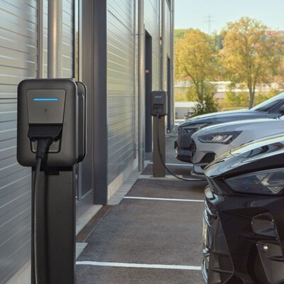 Sur un parking privé, des bornes de recharge witty pro de Hager sont en train de recharger des véhicules.