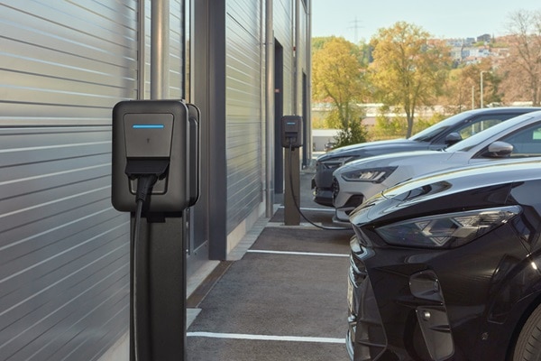 Sur un parking privé, des bornes de recharge witty pro de Hager sont en train de recharger des véhicules.
