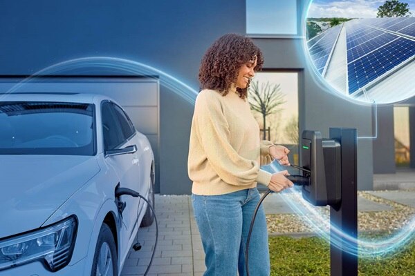 femme rechargeant son véhicule grâce à la borne de recharge qui utilise l'énergie solaire