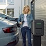 Femme qui recharge sa voiture sur un parking privé avec une borne witty pro de Hager