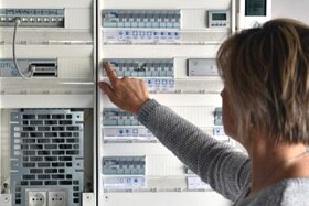 Femme testant son tableau électrique domestique Hager