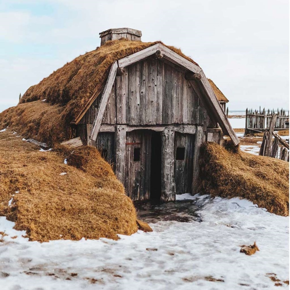 vieille cabane en bois entourée de foin dans la neige