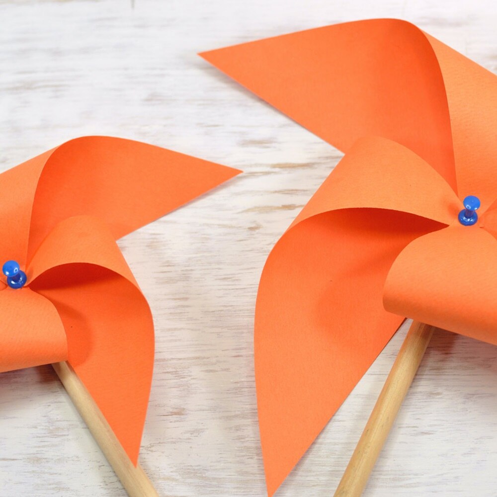 deux moulins en papier orange posés sur une table