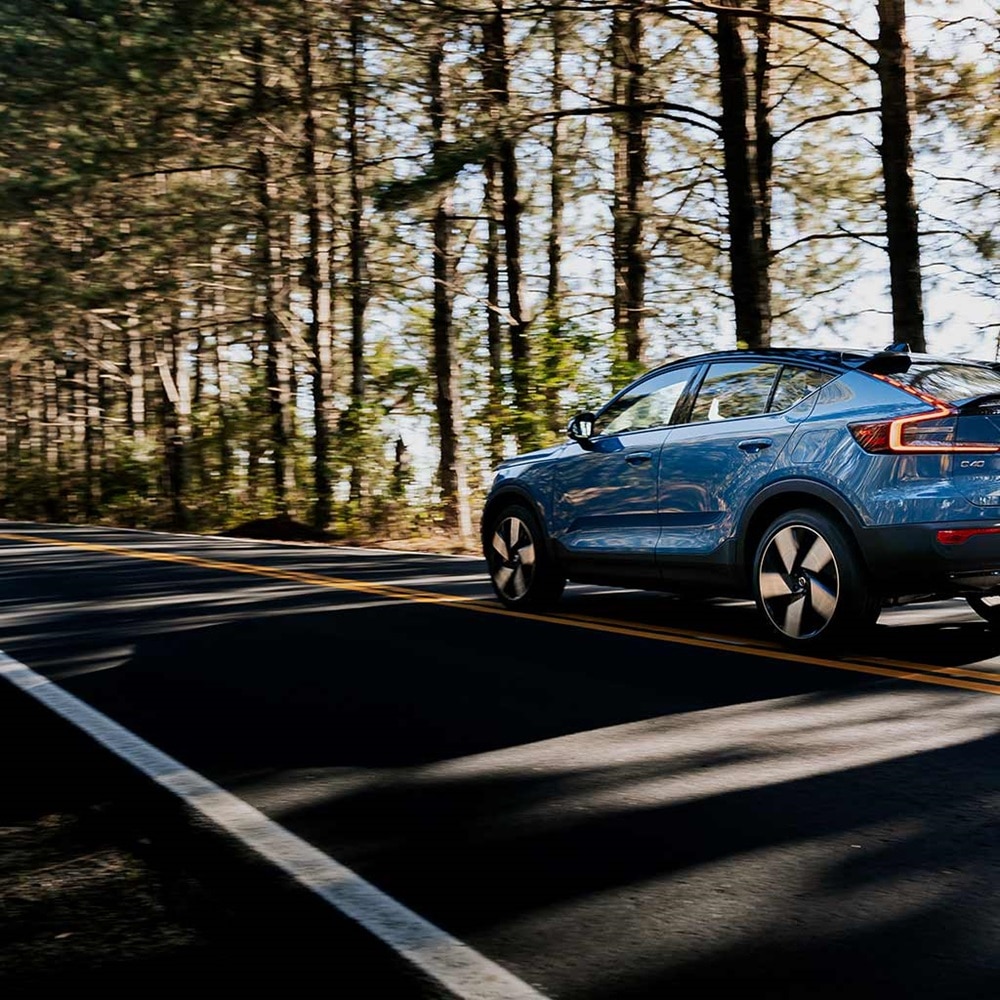 Véhicule électrique sur une route bordée d'arbres