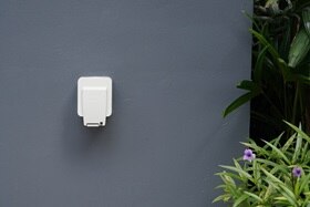 Prise extérieure Hager sur mur gris.