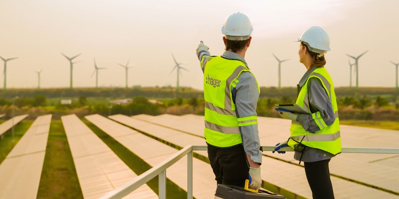 Employé de Hager pointant vers les éoliennes
